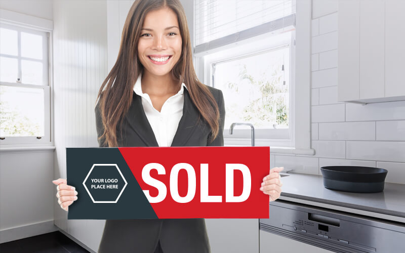 A Female Real Estate Agent In A Kitchen Holding A Sold Sign