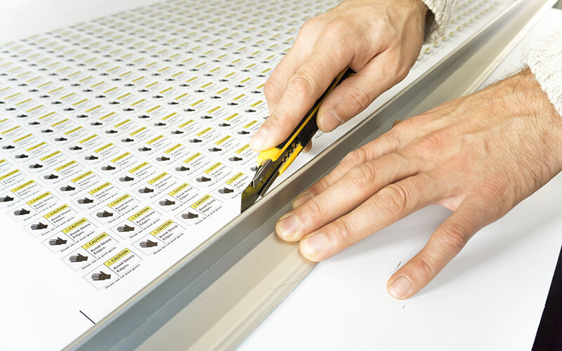 A Sheet Of Stickers Being Cut